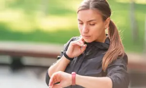 Kobieta sprawdza puls na zegarku. Zastanawia się, czy puls 50 jest dobry po treningu.