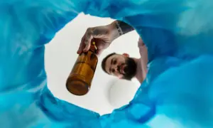 Mężczyzna wyrzuca butelkę, symbolizując początek regeneracji organizmu po odstawieniu alkoholu.
