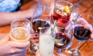 Ludzie wznoszą toasty różnymi napojami. Pamiętaj, że woda to najlepsze, co wypłukuje alkohol z organizmu.