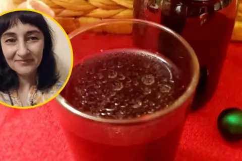 Kobieta z uśmiechem obok szklanki z zakwasem buraczanym. Dowiedz się o zakwas buraczany przeciwwskazania.