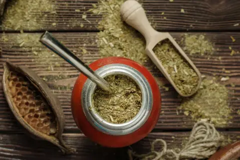 Naczynie z yerba mate, bombilla, drewniana łopatka z suszem. Choć yerba mate ma wiele zalet, warto pamiętać o jej negatywnych właściwościach.