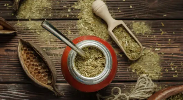 Naczynie z yerba mate, bombilla, drewniana łopatka z suszem. Choć yerba mate ma wiele zalet, warto pamiętać o jej negatywnych właściwościach.