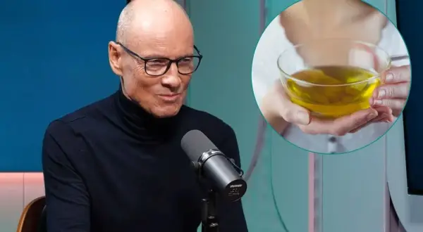 Mężczyzna w okularach i czarnym golfie rozmawia przy mikrofonie. Obok w okręgu widać dłonie trzymające miseczkę z żółtym płynem, być może podpowiedź, jak się odstresować.